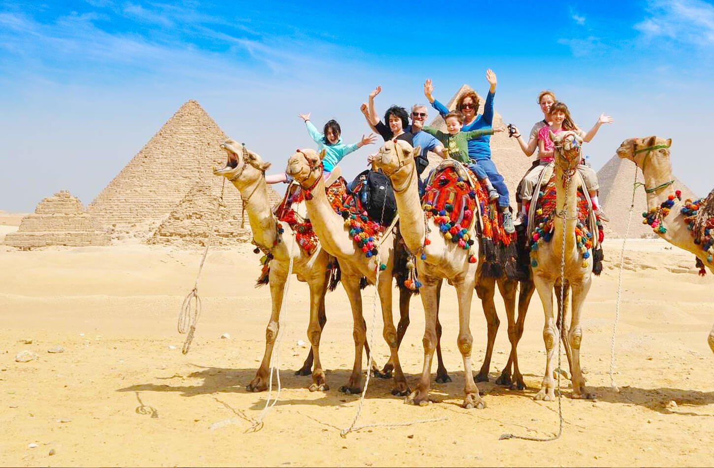 Una Foto Maravillosa De Una Familia Dentro De Las Piramides Y Cabalgando Camellos