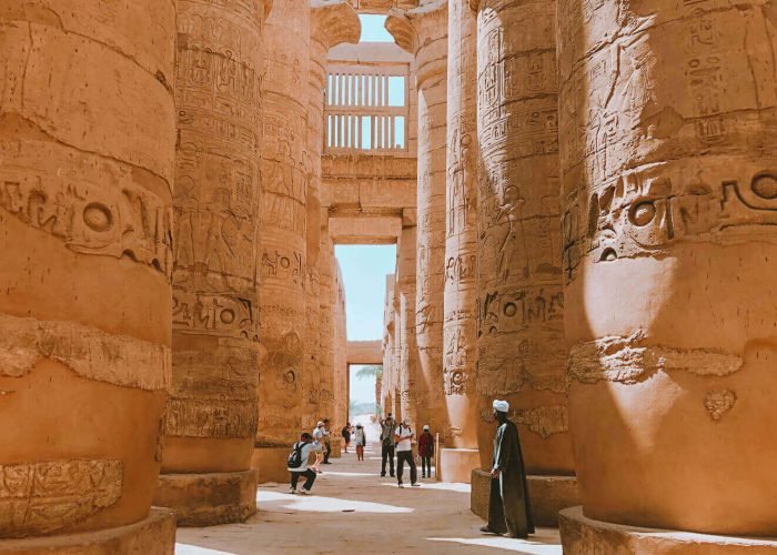 Una Imagen De Algunos Visitantes Cerca De Las Columnas Del Templo De Karnak