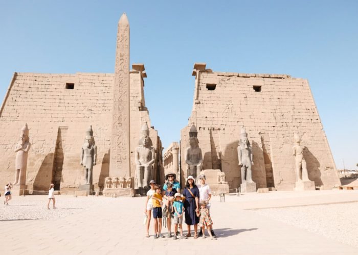 Una Foto Maravillosa De Una Familia Delante Del Templo Luxor